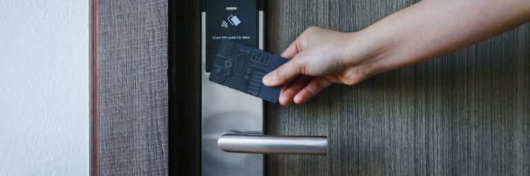 Hotel, vakantiehuisje of B&B, hier zie je een hand die met een hotelcard de kamerdeur van een hotel openmaakt